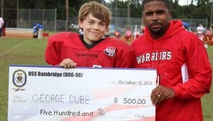 Seventh-grade football player George Dube’ is presented with a special scholarship by Bennett's Creek Warriors scholastic director Brian Jolley. 