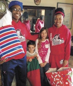 Members of the Nansemond River girls’ basketball team deliver gifts on Christmas Day to two happy young children. From left: Annecia Woods, Joshua Meeks, Samantha Meeks and Kaela Arroyo.