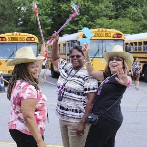 At Mack Benn Jr. Elementary School on Friday afternoon, faculty members Sharon Watson, Gwendolyn Artis and Frieda Cason celebrate the last day of school, as student load the buses behind them.