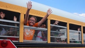 Creekside Elementary School students wave farewell to faculty and staff as their bus speeds them away to a summer of fun. 