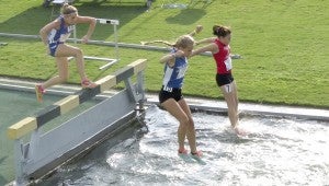 Cierra Sheppard of Suffolk, center, flies through the air during the girls' 2,000-meter steeplechase in the 15- to 16-year-olds' division on Aug. 5 at Norfolk State University. She finished 17th with a time of 9:36.26. Behind her is Caitlynn Melanson of Carrollton, who took 25th with a 9:55.98 time. (Lynn Melanson photo)