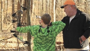 Steven Jensen of Carrollton gives grandson Caleb Richardson 11, of Seaford, a bit of guidance on how to set up his shot at one of the 26 targets along the Kingsboro Bowmen’s range.