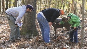 Steve Jensen and his son-in-law, Paul Richardson, and grandson, Caleb, compare the accuracy of their shots.