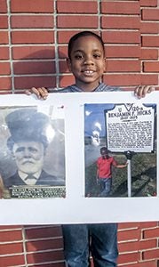 Tristan Hicks, 7, shows off the post he made about his relative, Benjamin F. Hicks, for a presentation at his church.